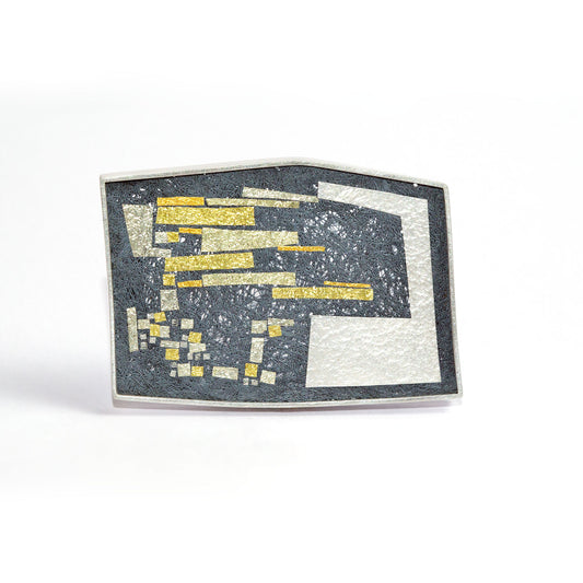 Silver brooch with geometric pattern on a dark background